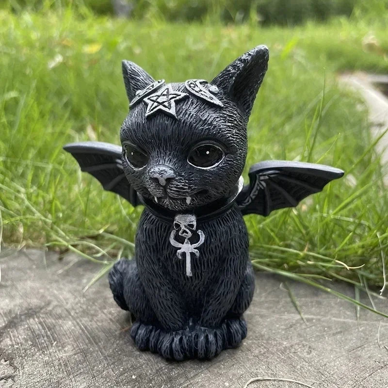 Black cat figurine with wings and pentacle decorations on a grassy background