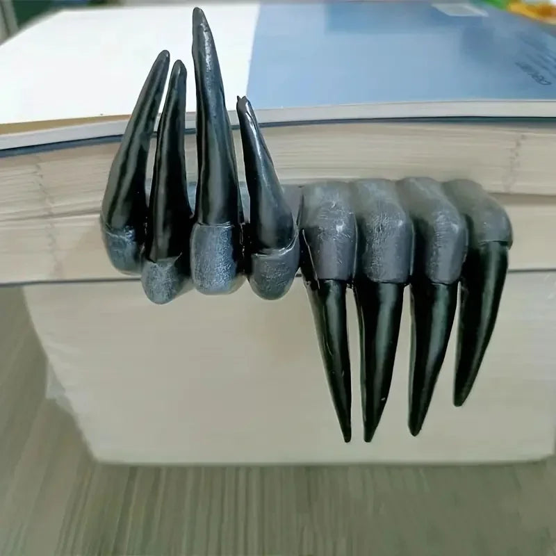 Black claw-like object on a stack of books