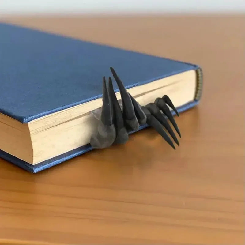 Black spiked object on a blue book on a wooden surface