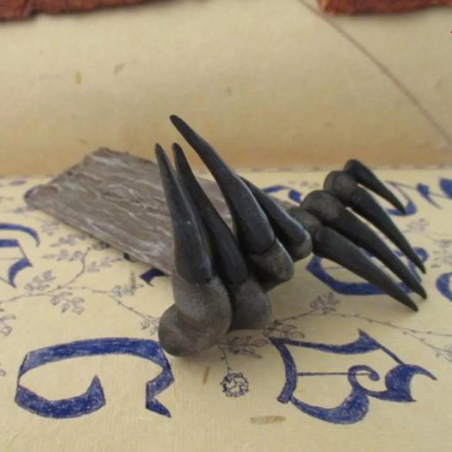 Set of black claws on a textured surface with blue text