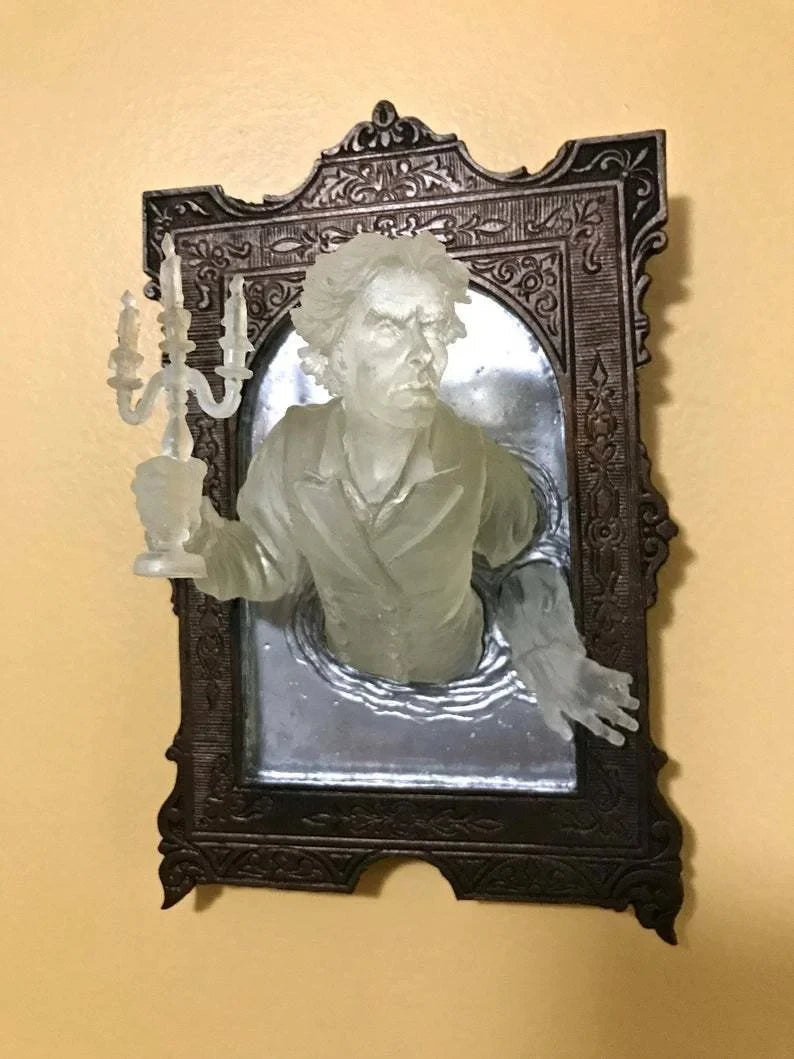 Decorative wall art with a framed portrait of a person holding a candle against a beige background
