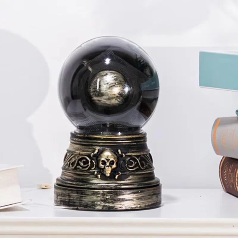 Decorative crystal ball with ornate base on a white surface