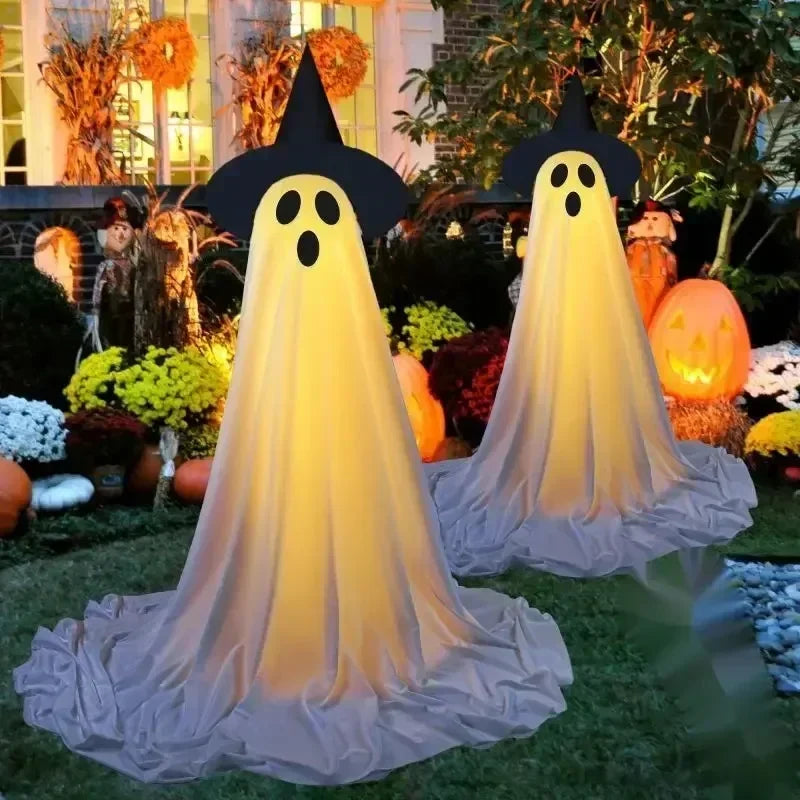 Halloween-themed decorations including ghosts, pumpkins, and scarecrows in a garden setting.