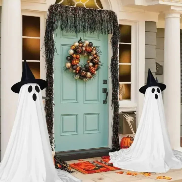Halloween decorations including ghosts, a wreath, and pumpkins on a front door.