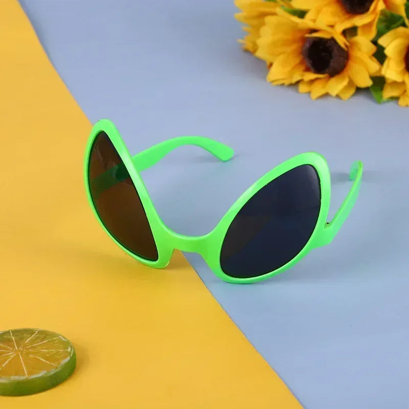 Neon green sunglasses on a yellow and blue background with sunflowers.
