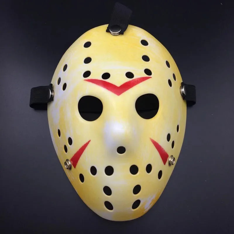 Yellow hockey mask with black eye holes and red accents on a dark background