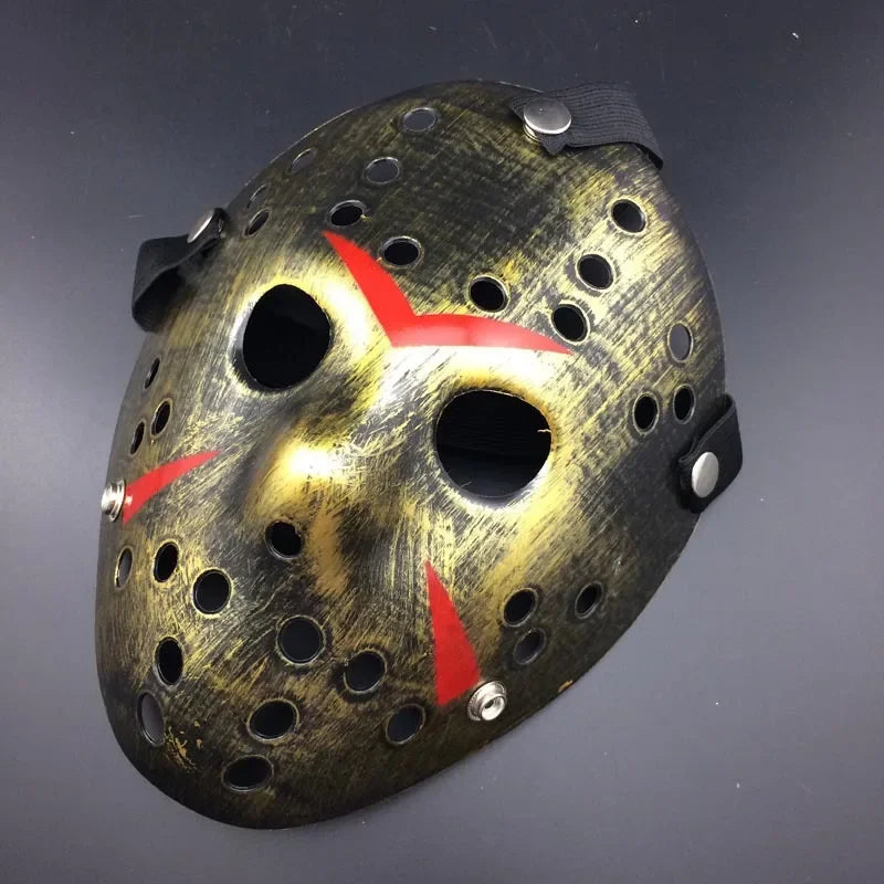 Mask with a worn-out look, gold and black color scheme, and red accents on a dark background
