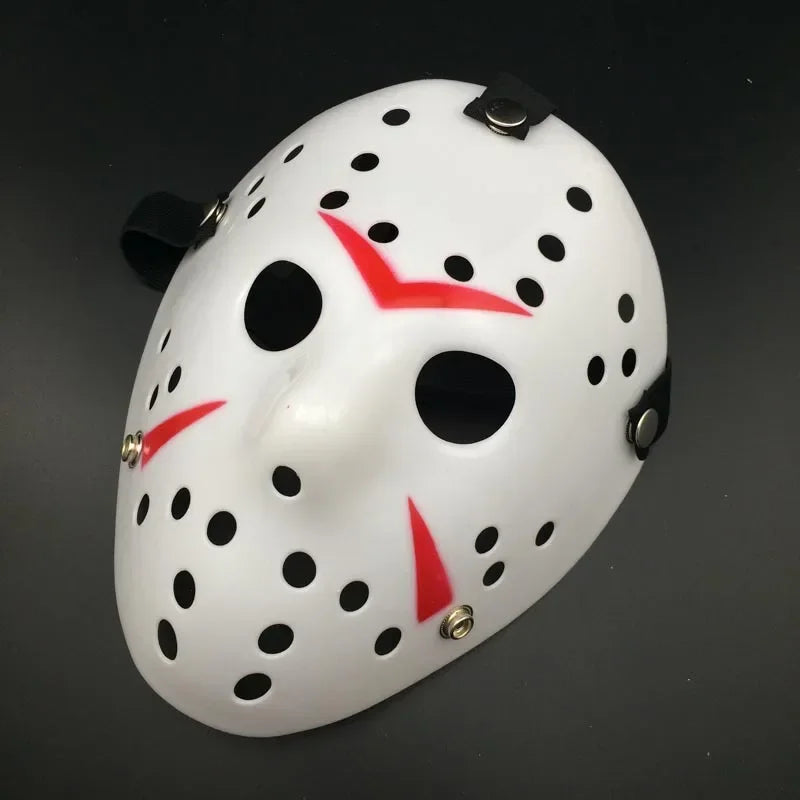 White mask with black holes and red accents on a dark background