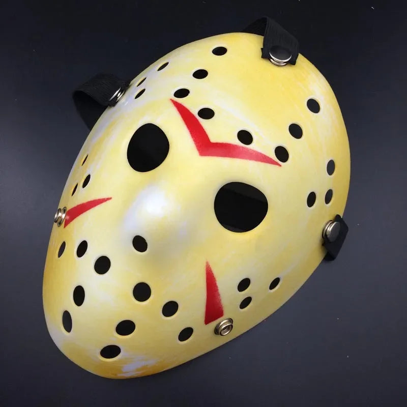 Yellow mask with black dots and red accents on a dark background