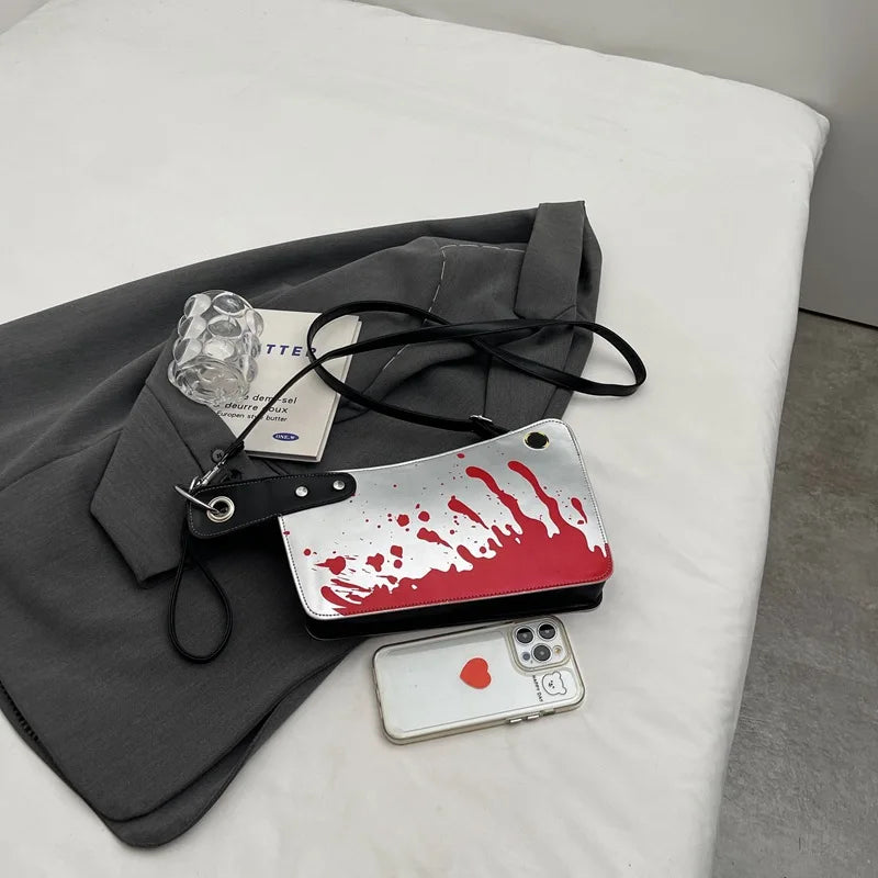 License plate with blood splatter design on a white surface with a phone and gray fabric.