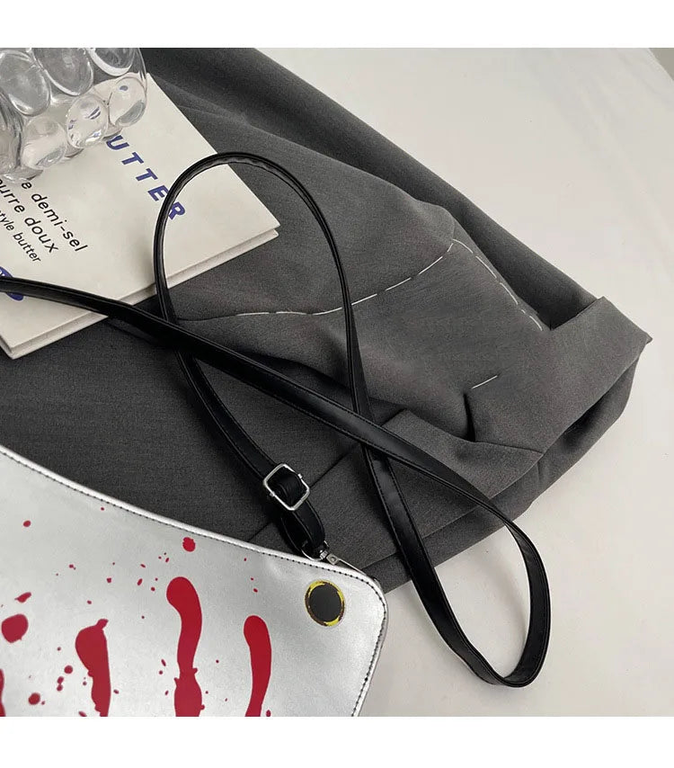 Gray bag with a black strap on a white surface