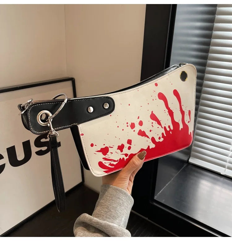 Hand holding a wallet with red blood splatter design in an indoor setting