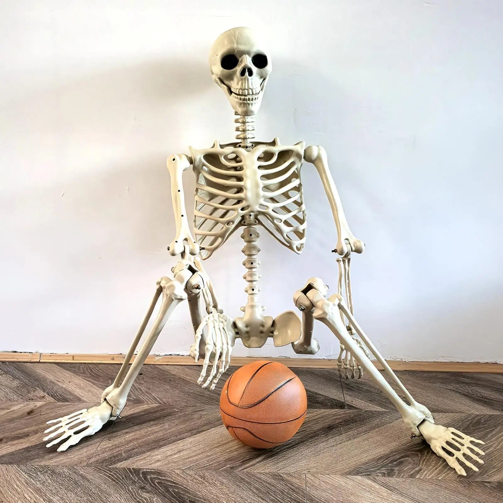 Skeletal figure interacting with a basketball on a wooden floor.