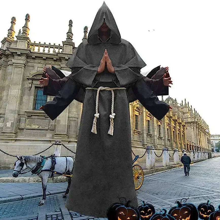 Person in a dark hooded robe with a rope around the neck on a street with a horse and cart, and pumpkins in the foreground.