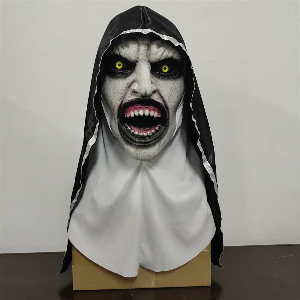 Horror-themed mask with a hood on a cardboard stand against a plain background