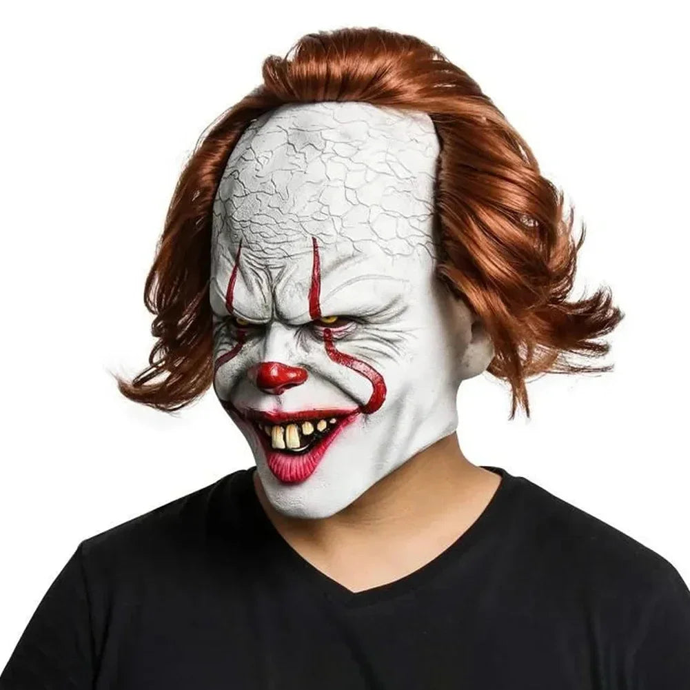 Person wearing a clown mask with red hair on a white background