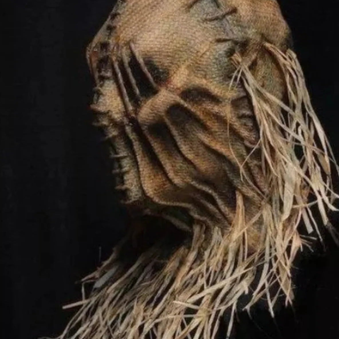 Textured mask with frayed edges on a black background