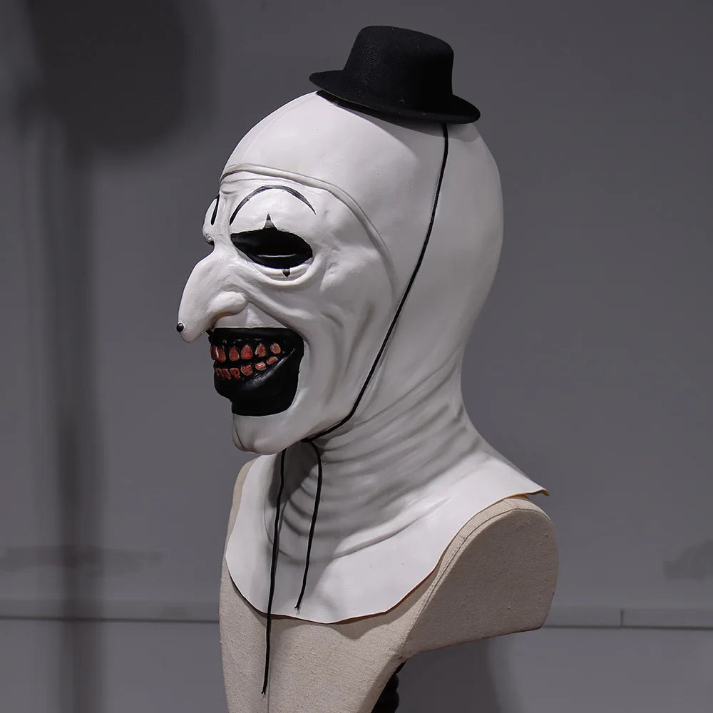 White mask with black hat and red teeth on a mannequin head against a gray background