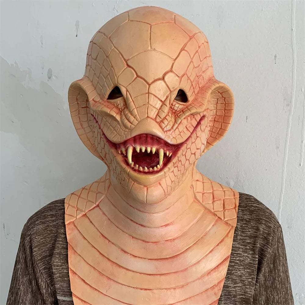 Person wearing a detailed lizard-like mask against a plain background