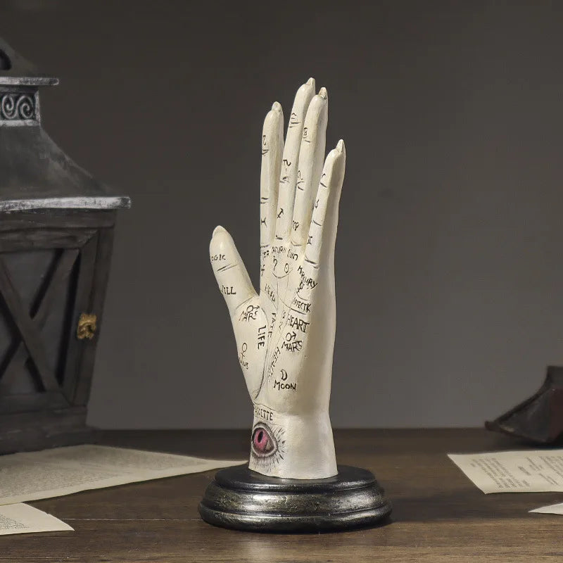 Decorative hand sculpture with inscriptions on a dark background