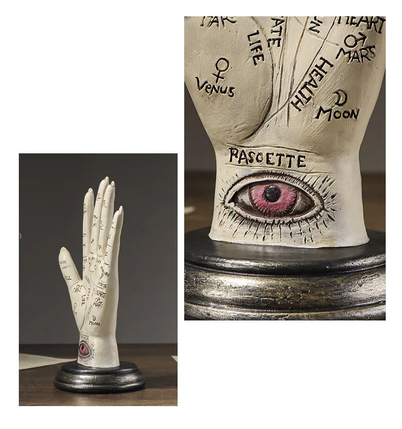 Decorative sculpture of a hand with inscriptions and an eye on a wooden stand.
