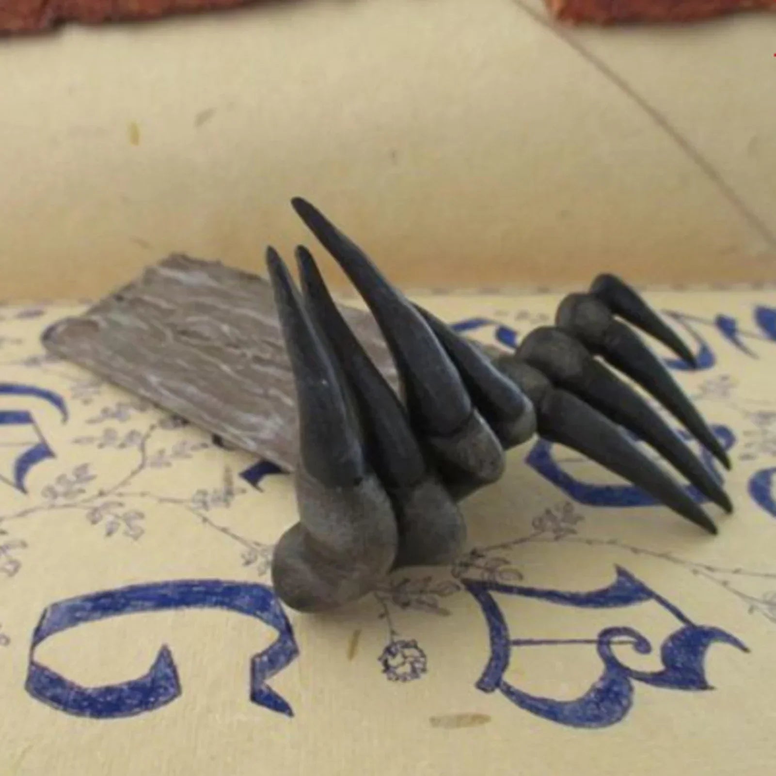 Set of black claws on a textured surface with blue text
