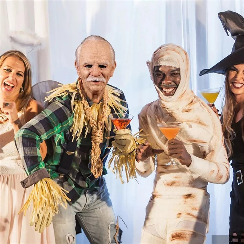 Four people in Halloween costumes holding drinks against a white curtain background