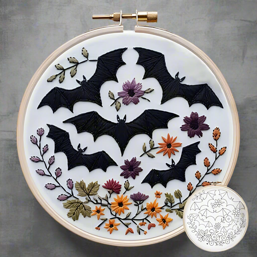 Embroidery hoop with black bats and flowers on a white background