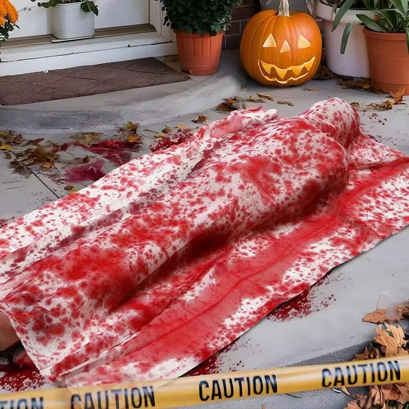 Halloween scene with a fake body covered in blood on a porch.