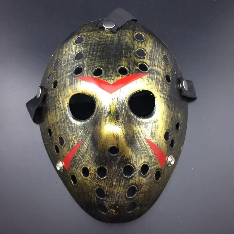 Halloween mask with a metallic gold finish and red accents on a dark background