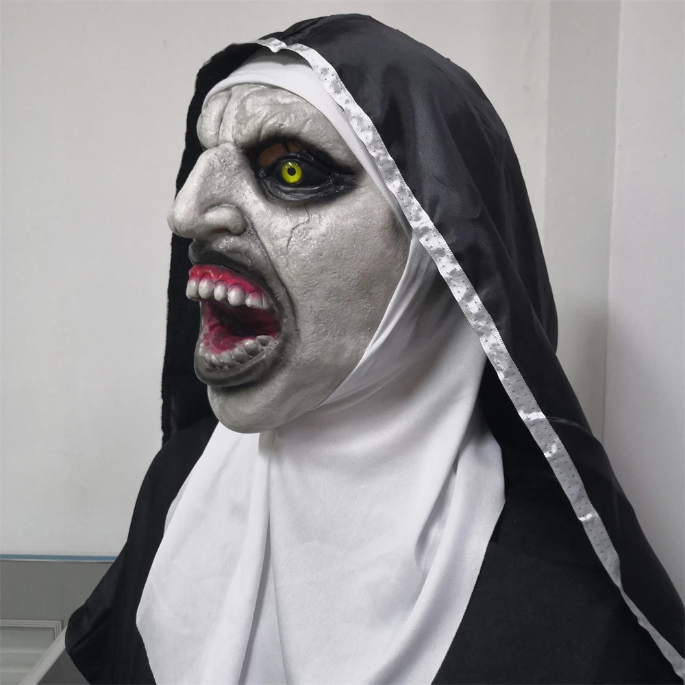 Halloween mask of a nun with black hood and white face on a plain background