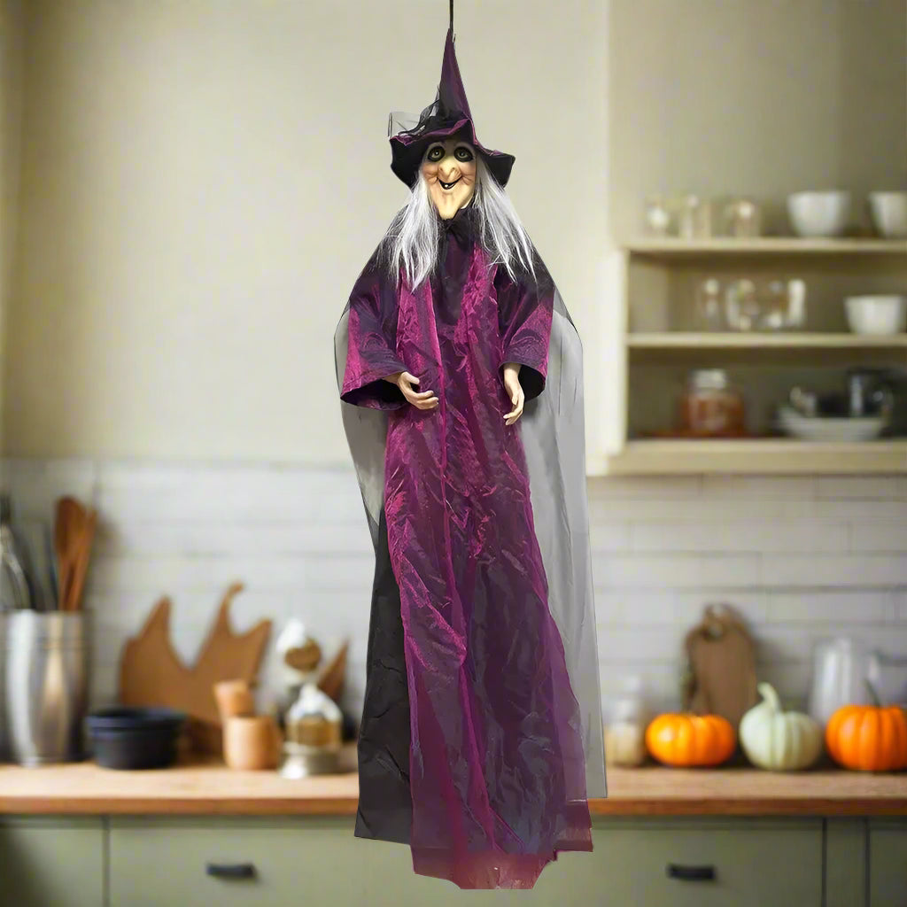 Halloween witch figurine with purple robe and black hat on a white background
